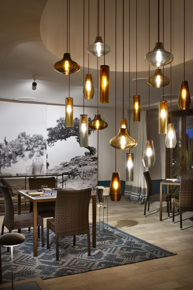 Applique ed illuminazione di design in una sala con due tavoli apparecchiati in modo elegante