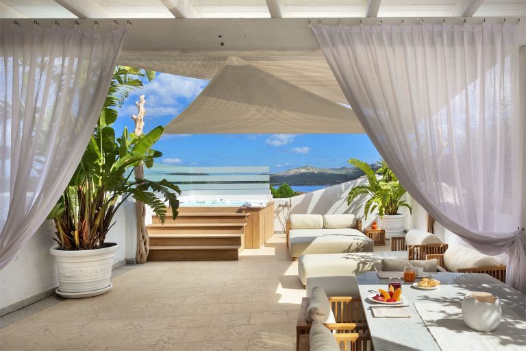 terrazza con vista mare e mini piscina e tavolo per la colazione, in una delle suite dell'hotel