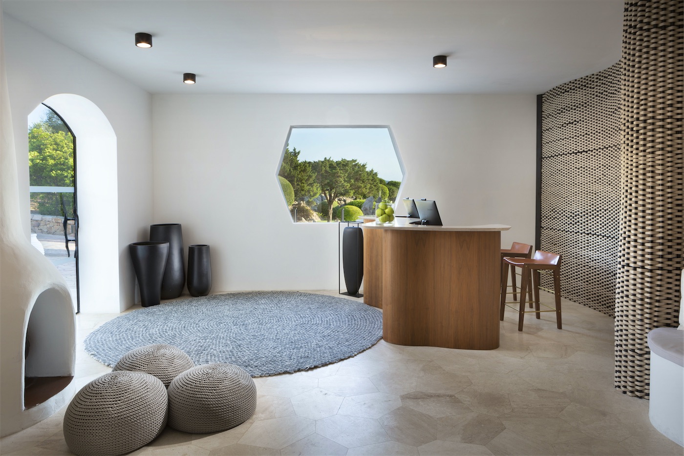 una moderna reception di albergo con arredamento minimalista, legno e pietra