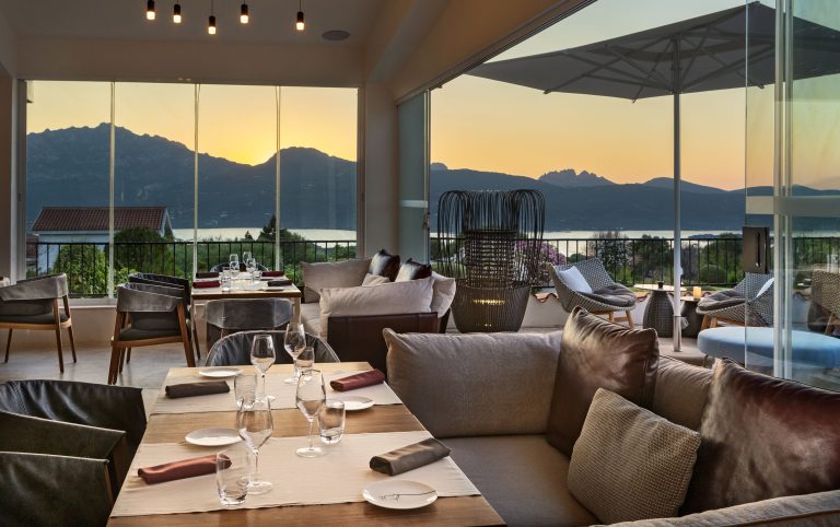 Una moderna sala ristorante con ampie vetrate e tavoli apparecchiati in modo elegante