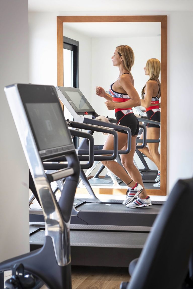 Una ospite fa ginnastica su un tapis roulant nella palestra dell'hotel