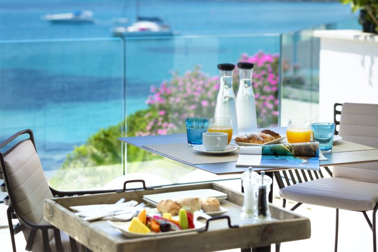 due vassoi su cui è servita una abbodante colazione, poggiati su un tavolo nella veranda vista mare della stanza