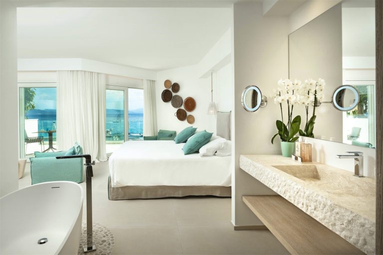 una suite con letto matrimonale, grande lavabo in marmo di Orosei e moderna vasca da bagno